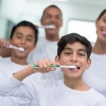 Happy family portrait brushing their teeth